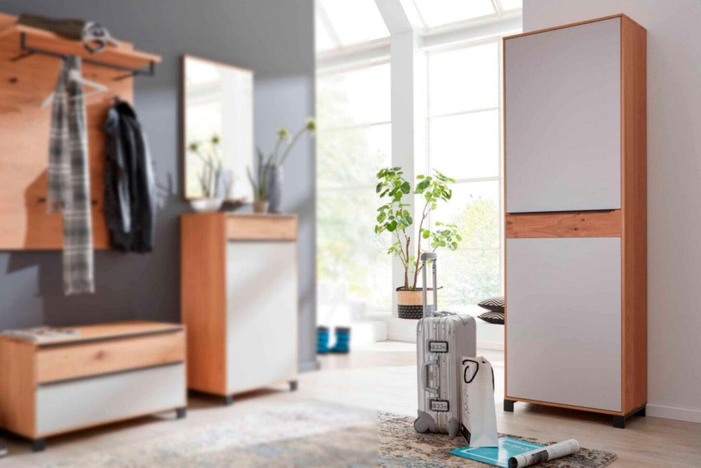 Heller Eingangsbereich mit dem VOSS MÖBEL | IL Interliving 6005 Dielenschrank in Eiche „Bianco“ und Sonnenlicht, das durch große Fenster hereinströmt.