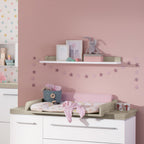 PAIDI Kira Kinderzimmer mit Wandregal in Kreideweiß/Eiche für Spielzeug, Deko, Kunstwerke und einer Sternengirlande über dem Wickeltisch.