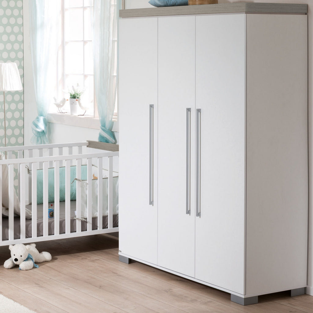 PAIDI Modell „Kira“ Kleiderschrank 3T von 0190 in einem Kinderzimmer mit Holzboden, blauen Akzenten und einem Plüschtier.