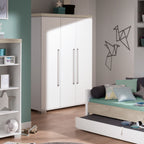 Das moderne Kinderzimmer mit türkisfarbenen Wänden ist mit einem Kleiderschrank „0190 PAIDI Kira 3T“, einem Tagesbett, Regalen und Origami-Vogel-Kunstwerken ausgestattet.
