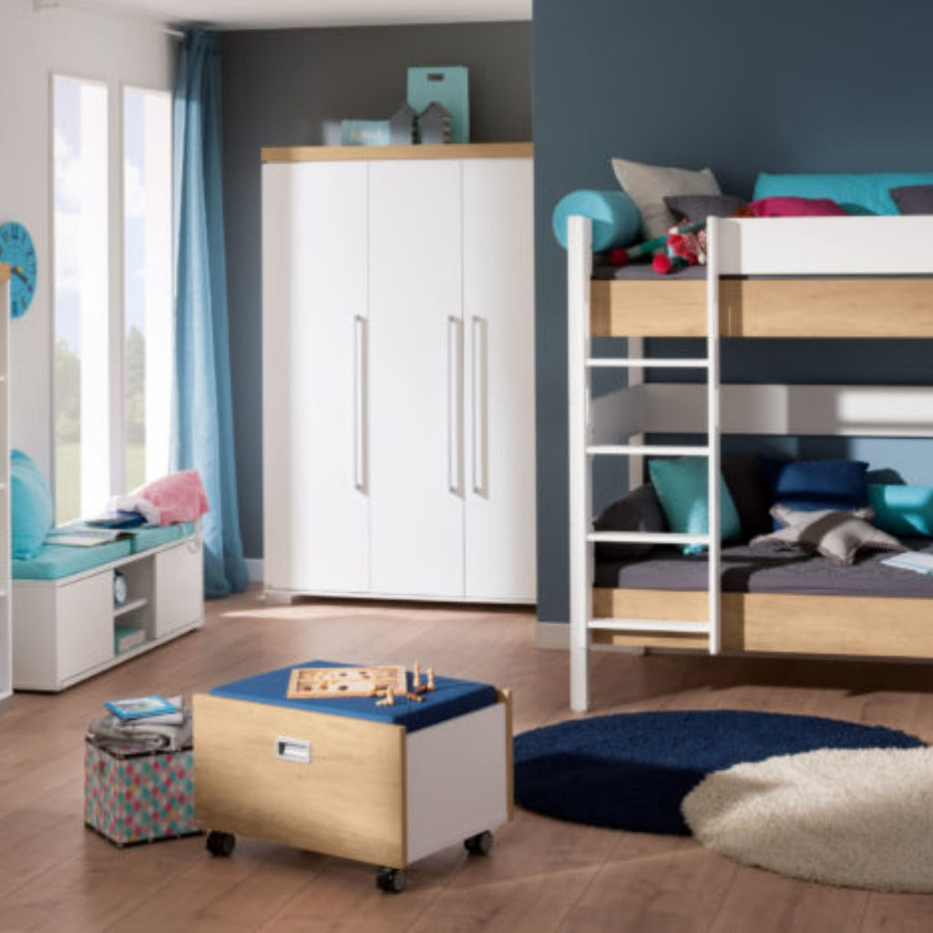 Modernes Kinderzimmer mit PAIDI Kira Rollbox, Hochbett, Kleiderschrank, Spielzeugkiste und blauen Akzenten – alles ordentlich angeordnet.