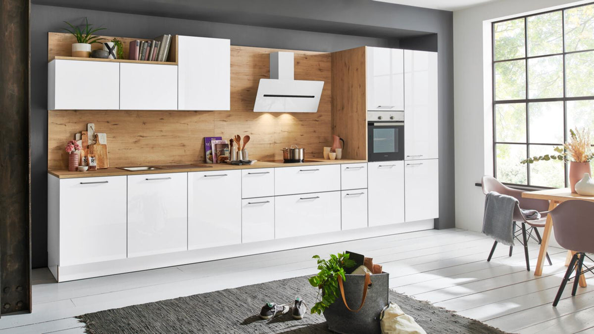 Nolte® Einbauküche „Lux“ von nolte® KÜCHEN: Akzente in Wildeiche, Hochglanzfronten in Arktisweiß und ein sonniger Essbereich.