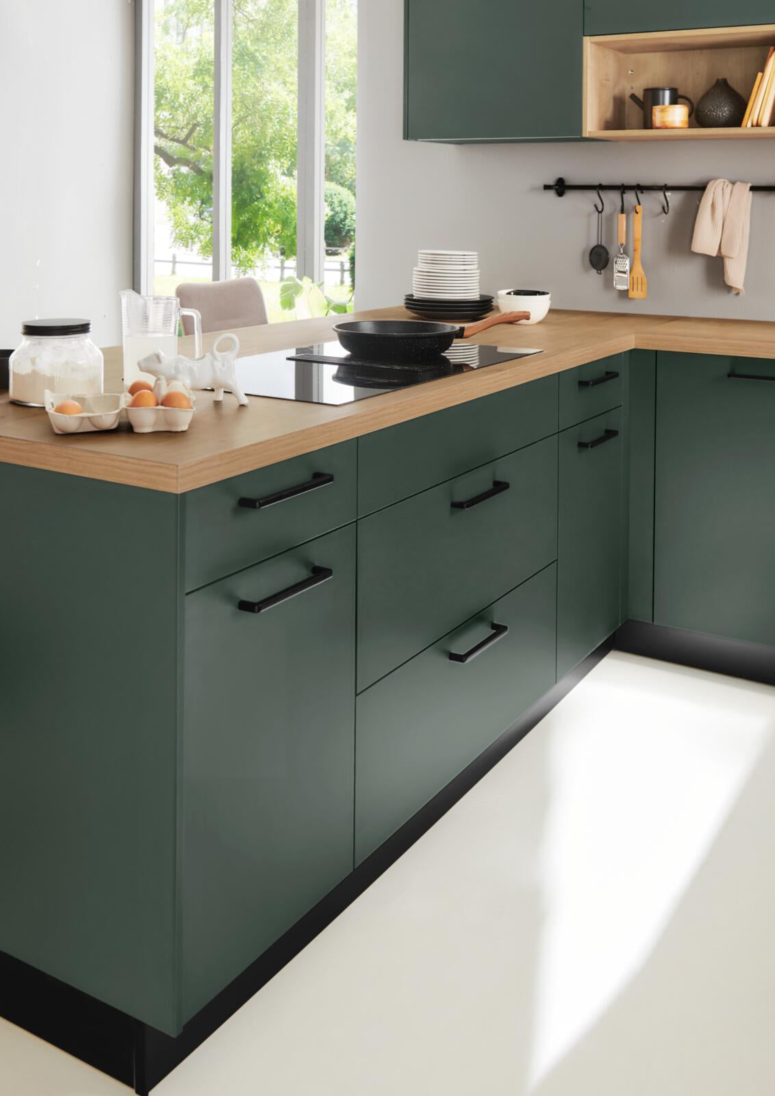 Nolte® U-Küche „Manhattan“ in Schwarz-Grün mit Holzakzenten, modern und lichtdurchflutet – mit Constructa-Geräten.