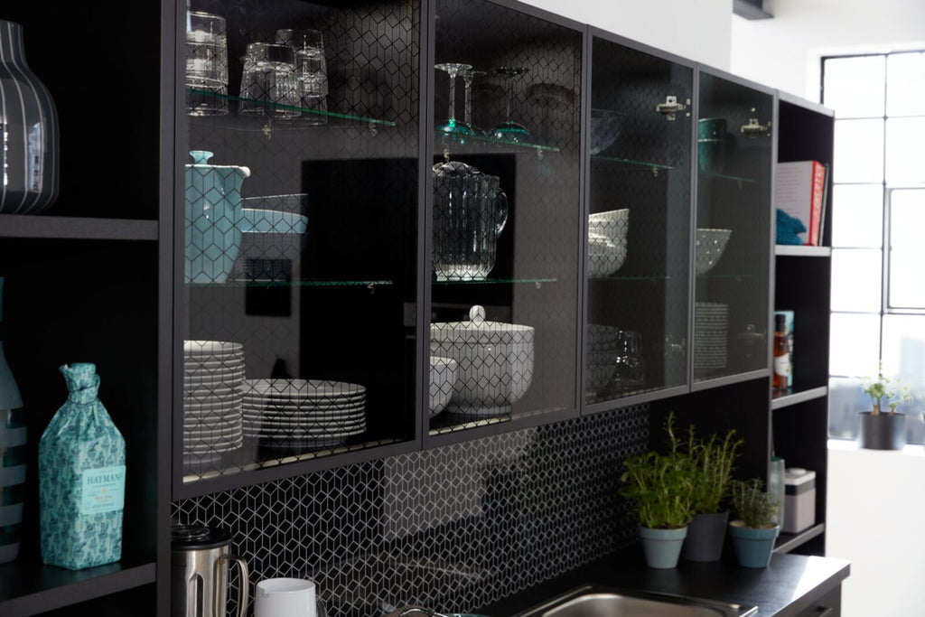 WERT KÜCHE® Franziska: Edles Design in Onyxschwarz, Glasfronten und Kräuter neben der Spüle setzen Akzente.