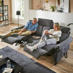Zwei Personen entspannen sich auf dem Rundsofa „OrthoSedis 4.0“ von Steinpol Polsteria mit Federkern in einem hellen, gemütlichen Wohnzimmer.