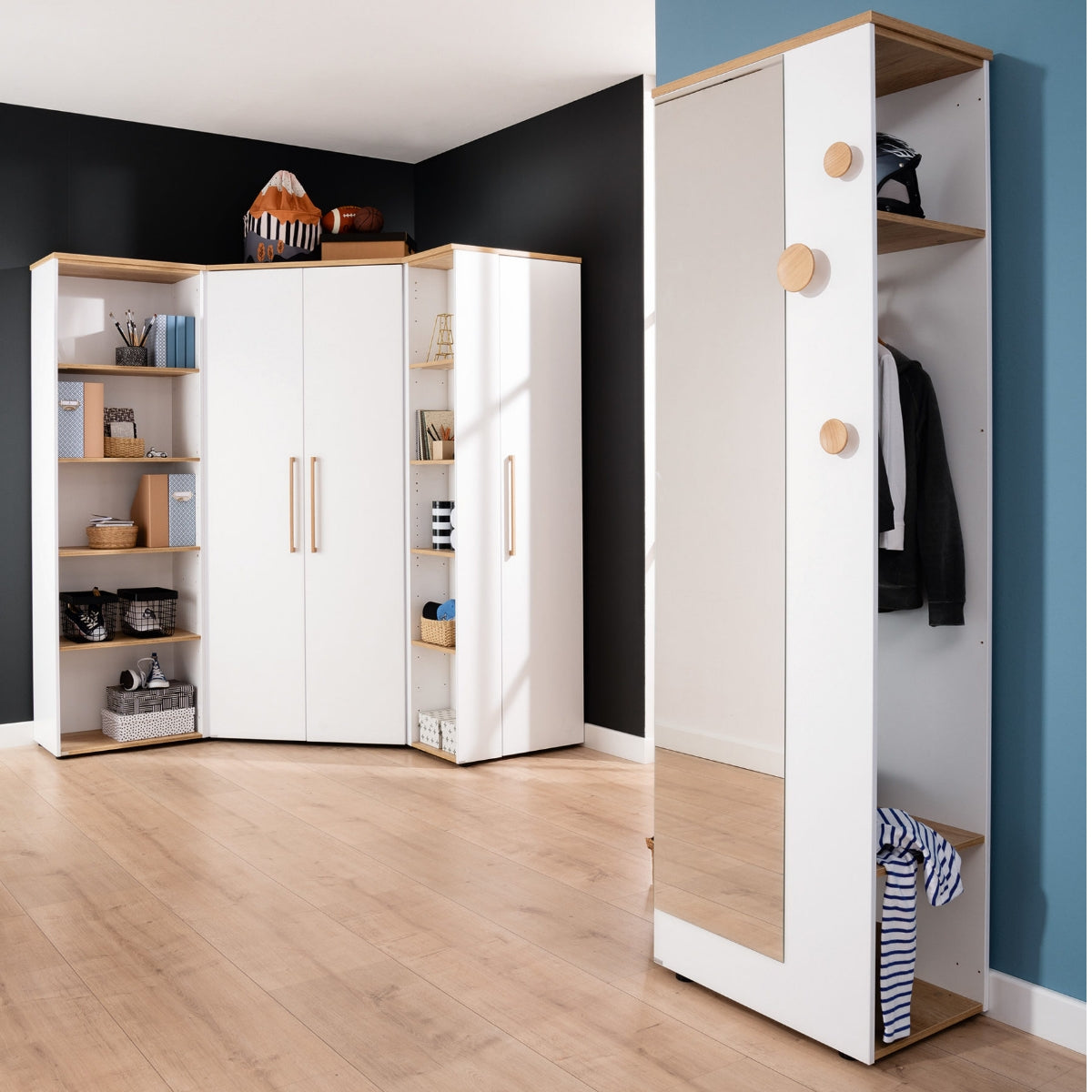 Modernes Zimmer mit dem PAIDI-Babyzimmerprogramm „Oscar“ – Garderobe 135 670 4, weiße Schränke, Regale und Holzboden.