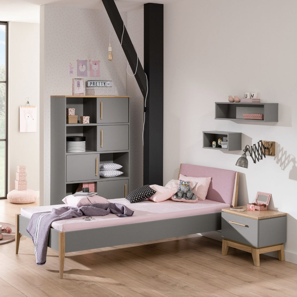 Modernes Kinderzimmer mit der PAIDI Wandbox „Oscar“, einem rosa Bett, einem Holzboden und einem Regal von PAIDI.