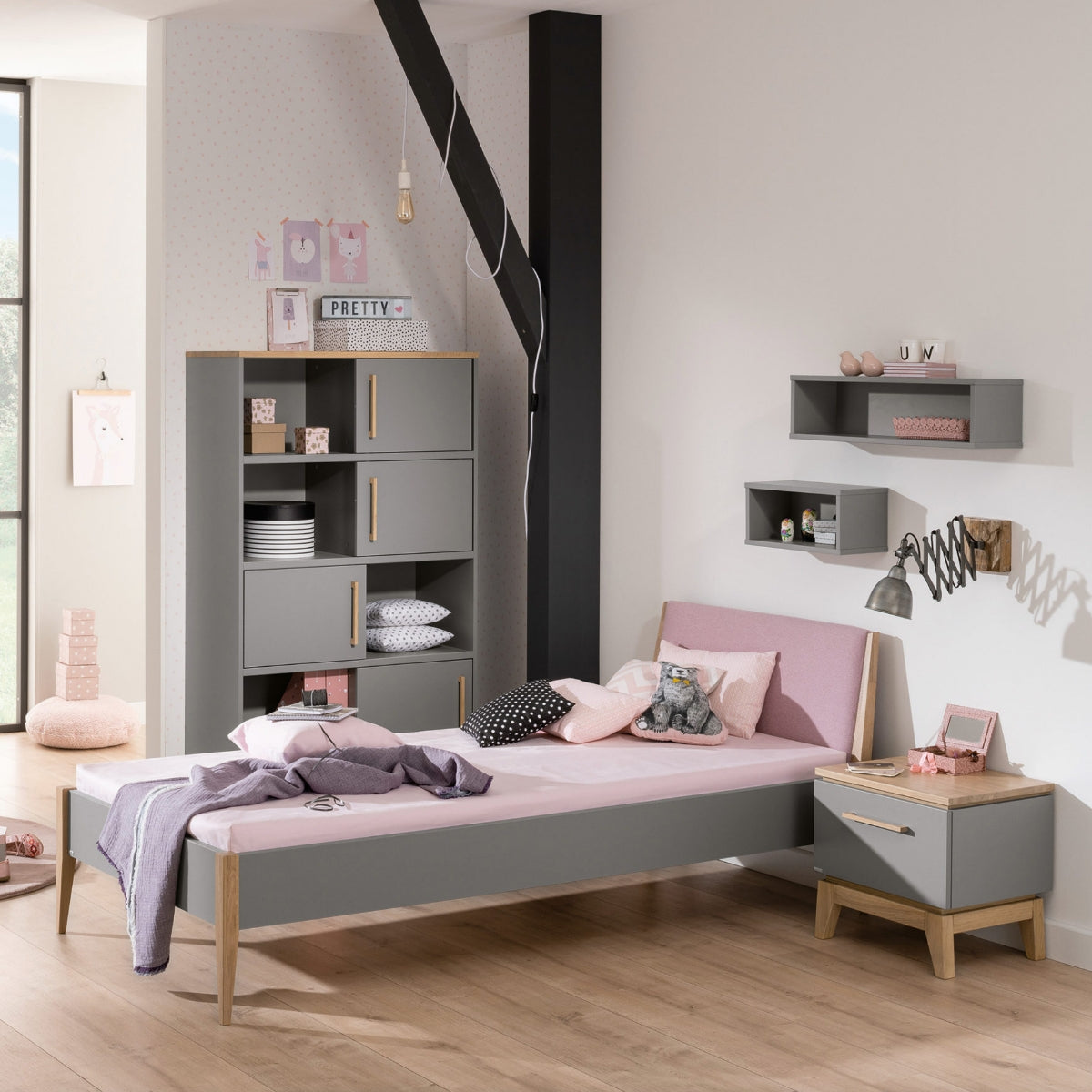 Modernes Kinderzimmer mit der PAIDI Wandbox „Oscar“, einem rosa Bett, einem Holzboden und einem Regal von PAIDI.