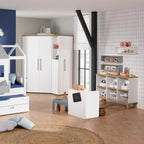 Kinderspielzimmer mit weißen Möbeln, Regalen und einem PAIDI Oscar Eck-Kleiderschrank in Nebraska-Eiche-Optik.