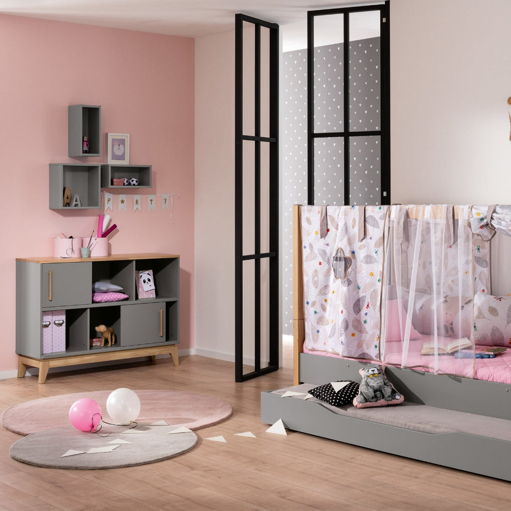 Modernes Kinderzimmer in Rosa und Grau, in dem das PAIDI Sideboard „Sten“ in Schiefergrau und massiver Eiche besonders zur Geltung kommt.