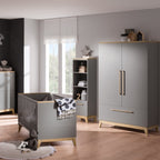 Modernes, graues Kinderzimmer mit dem PAIDI Babyzimmer Sten – Babybettgestell und Sonnenlicht, das auf den Holzböden tanzt.