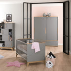 Modernes Kinderzimmer mit dem PAIDI Babyzimmer Sten – Babybettgestell, Holzboden, pastellfarbenen Akzenten und zartrosa Dekoration.