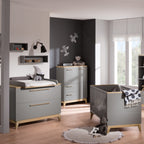 Modernes Kinderzimmer mit dem PAIDI Babyzimmer Sten – Babybettgestell, graues Babybett, Teddybären, Flugzeug-Wandbild und sanftem Fensterlicht.