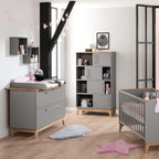 Modernes Kinderzimmer mit der PAIDI-Wickelkommode „Sten“ – graue Möbel, flauschige Teppiche und rosa Deko.