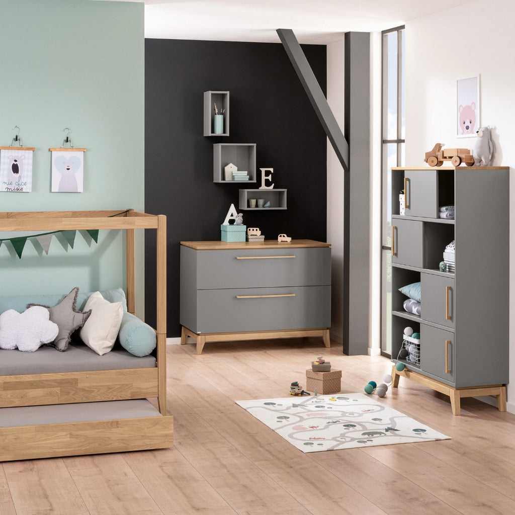 Modernes Kinderzimmer mit grauen Möbeln und Holzmöbeln, einer PAIDI-Wickelkommode, Plüschtieren und einer mintgrünen Wand.