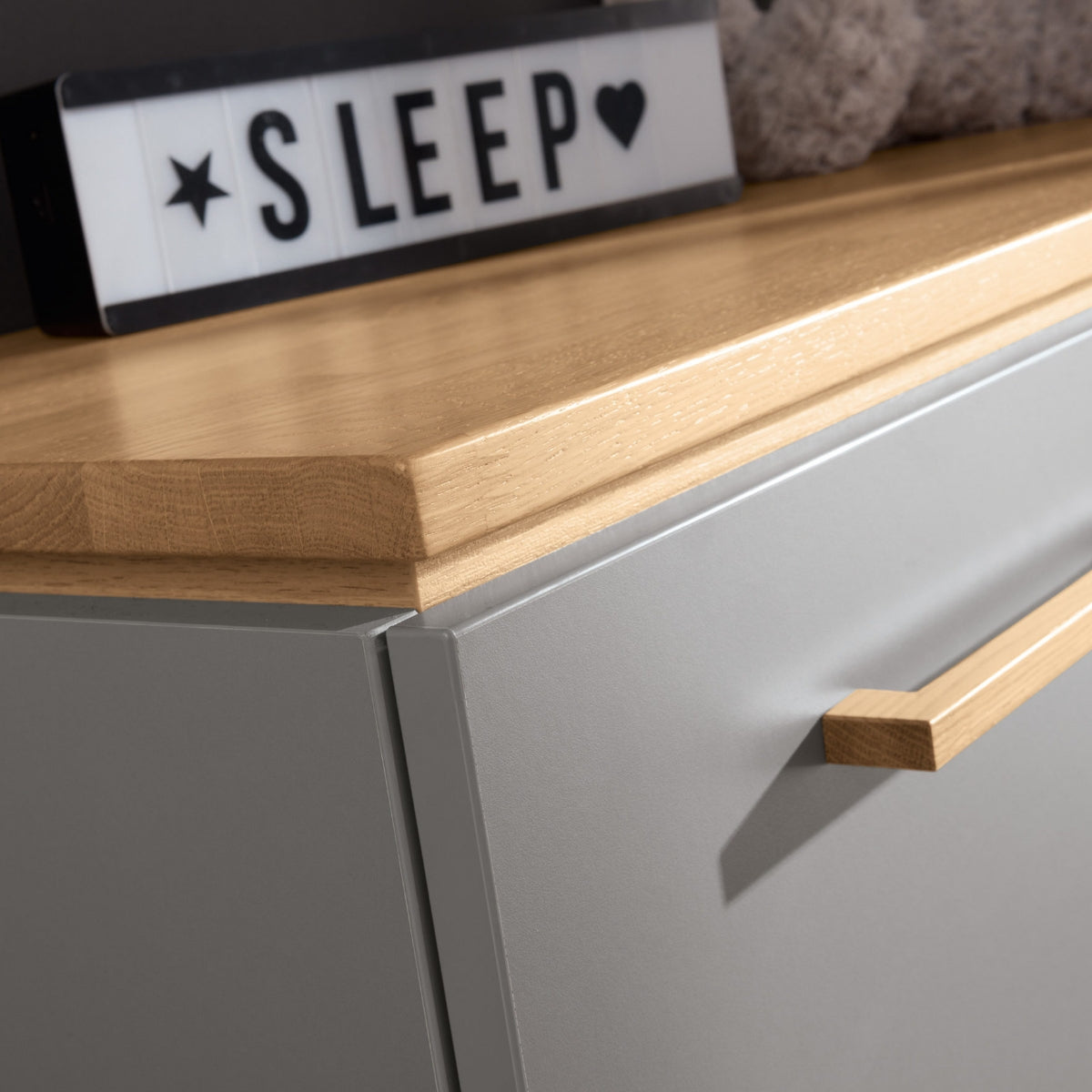 PAIDI Babyzimmer Sten – Wickelkommode aus Eiche, Nahaufnahme mit SLEEP-Leuchte und Herzsymbol.