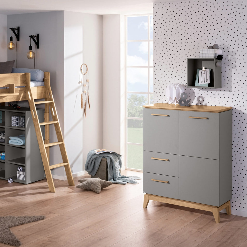Modernes Kinderzimmer mit einem PAIDI Babyzimmer-Hochregal „Sten“, einem Hochbett, einer grauen Kommode und einer Akzentwand mit Polka-Dots.