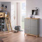 Modernes Kinderzimmer mit einem PAIDI Babyzimmer-Hochregal „Sten“, einem Hochbett, einer grauen Kommode und einer Akzentwand mit Polka-Dots.