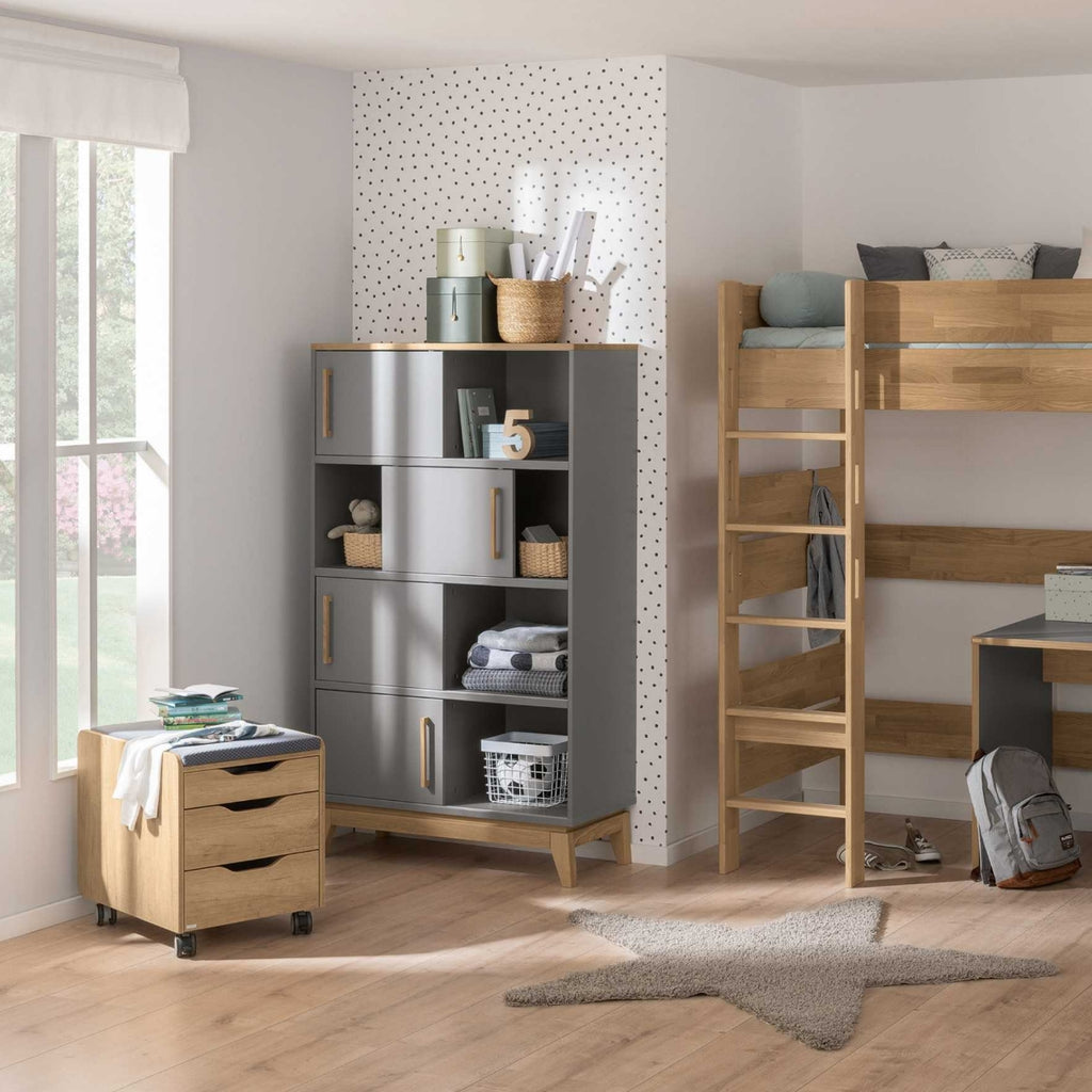 Kinderzimmer mit dem PAIDI-Stauraumelement „Sten“, einem Etagenbett, einer Rollkommode und einem Sternenteppich auf einem Boden aus massiver Eiche.