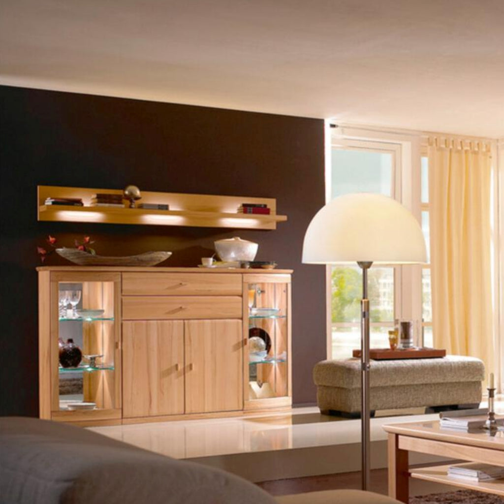 Modernes Wohnzimmer mit Holzmöbeln, dem RMW Vermont Sideboard, Glasregalen und beigen Vorhängen.