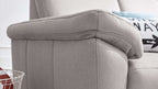 Ein graues Sofa mit strukturiertem Bezug, das einen weichen Armlehnenbereich zeigt, daneben liegt ein dekorisches Kissen.