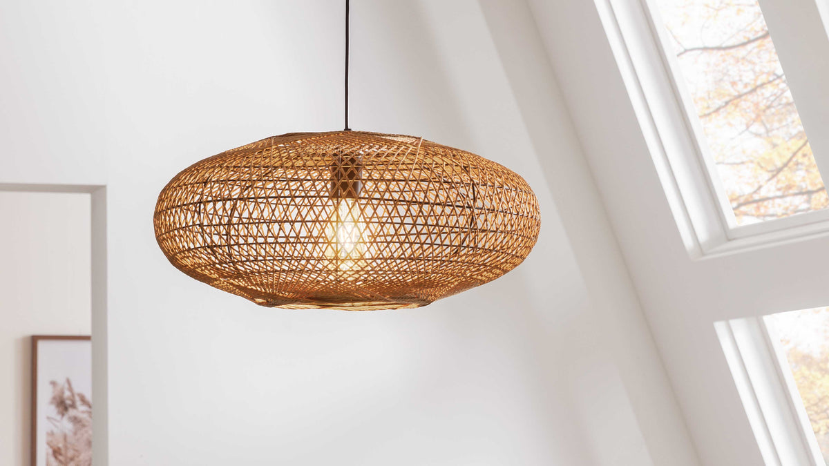 Pendelleuchte aus geflochtenem Rattan in ovaler Form mit sichtbarem Edison-Glühbirnen-Einsatz, aufgehängt an einer schwarzen Schnur.