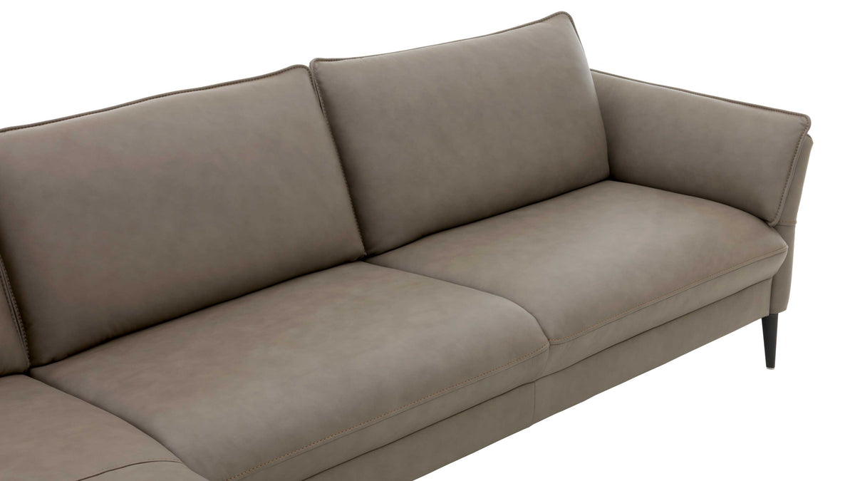 Beige, gepolsterte Couch mit leicht abgerundeten Armlehnen und schmalen schwarzen Füßen, die einen modernen Stil vermittelt.