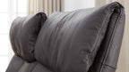 Der altgraue Kopfteil eines Polstersofas mit weichem, genarbtem Bezug und sichtbaren Nähten.